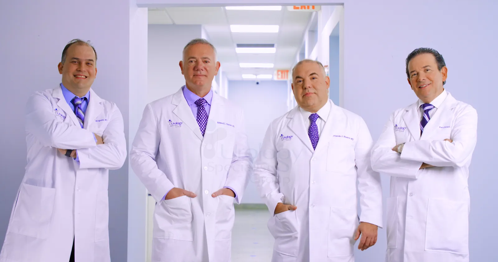 Cuatro urólogos del grupo, en bata, en el pasillo de la consulta