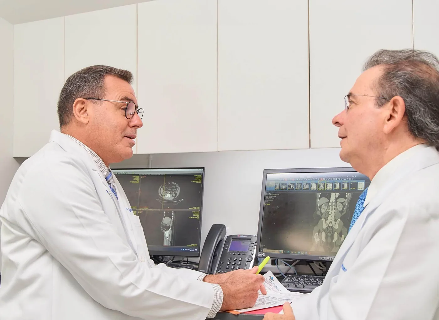 Dos urólogos revisan estudios de imagen en las pantallas de la consulta