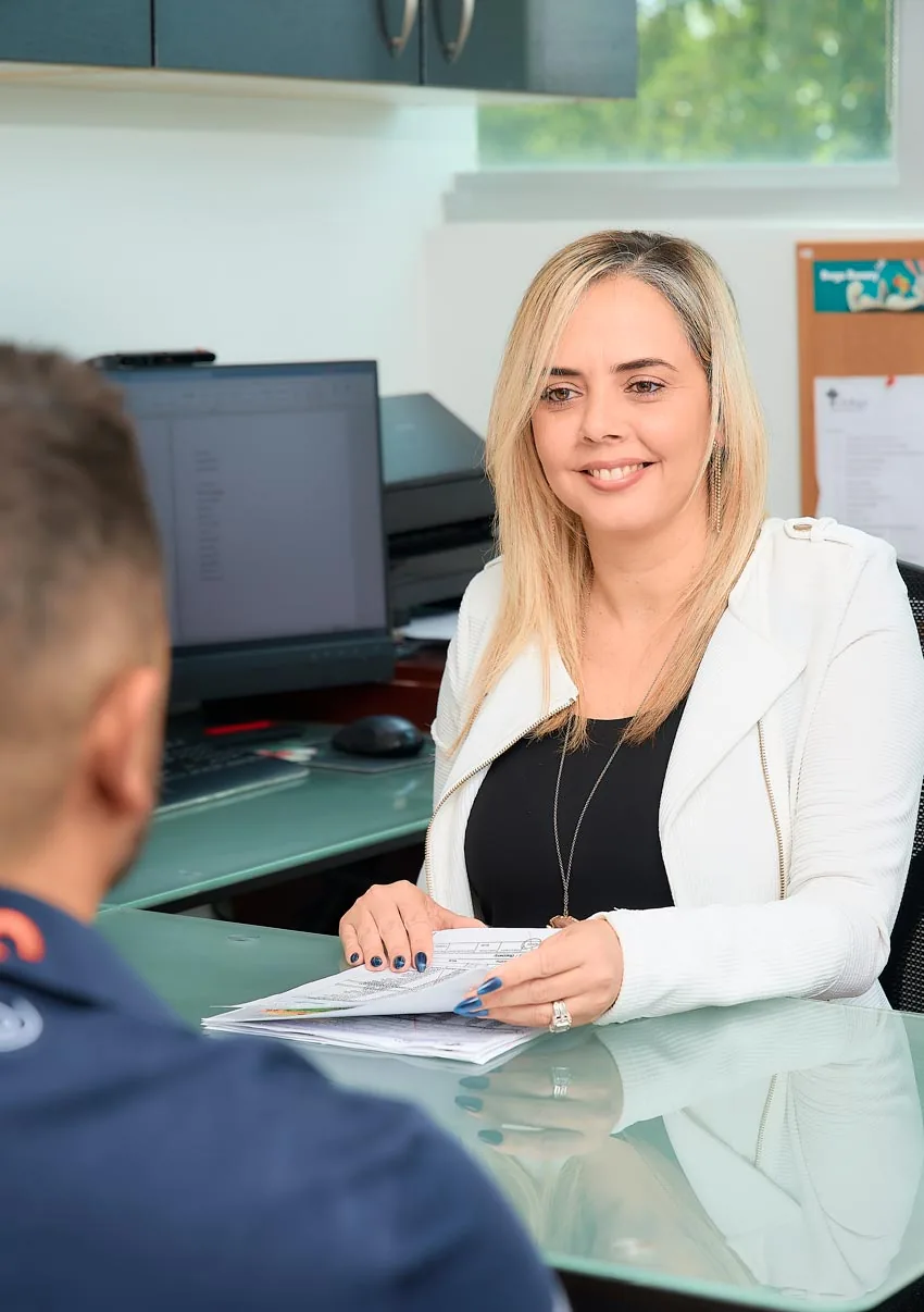 Una integrante del equipo atiende a un paciente en el mostrador de recepción